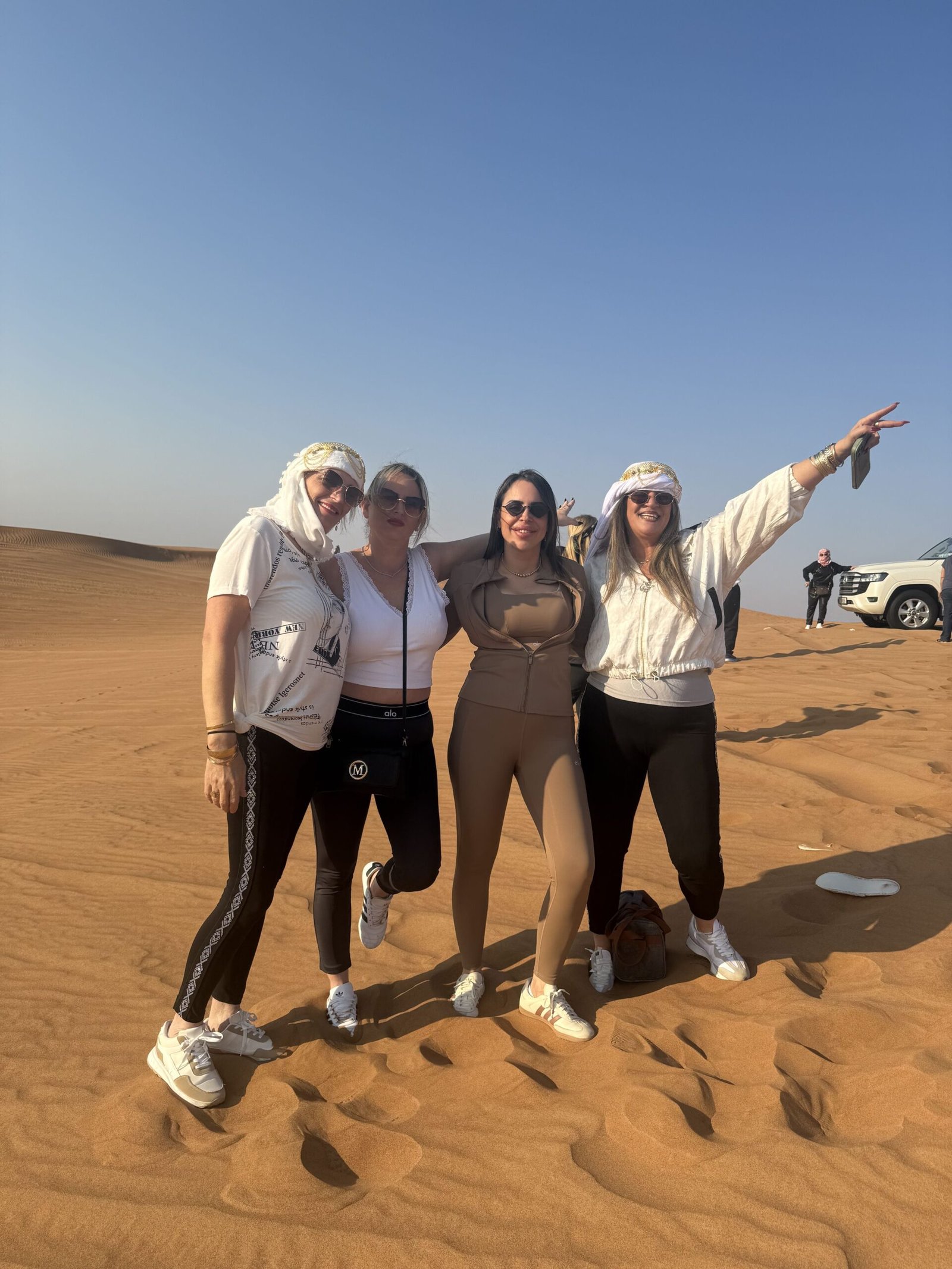 Sandboarding down the red dunes on a morning desert safari