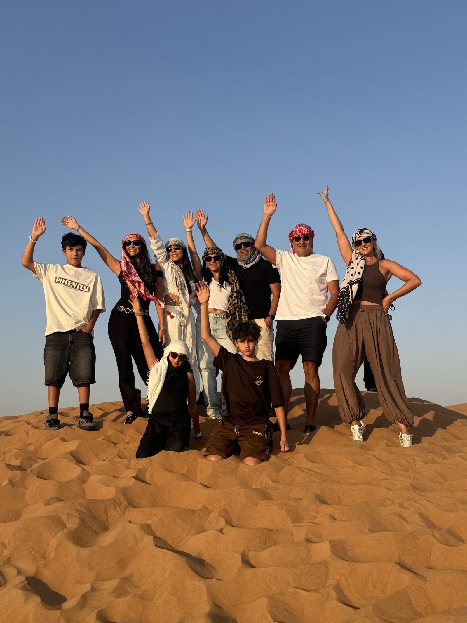 Sandboarding on red dunes during evening desert safari